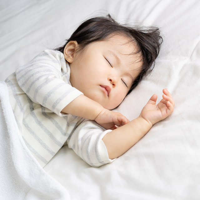 お布団で眠るお子さま